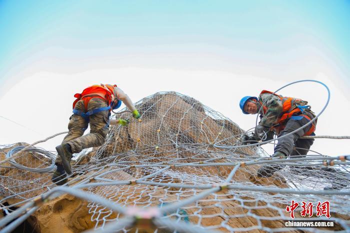 图为兰州铁路局兰州西工务段铁路职工固定柔性主动钢丝网 王光辉 摄