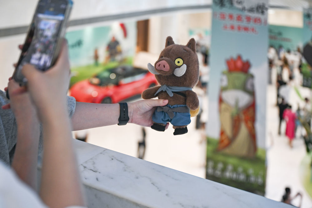 7月22日晚,影迷携带《浪浪山小妖怪》电影周边产品在首映活动现场拍照。新华社记者 陈浩明 摄