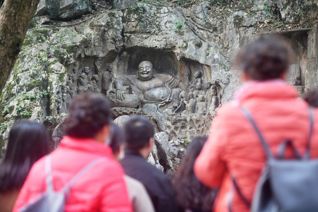 首批免票游客在飞来峰观看石窟造像。