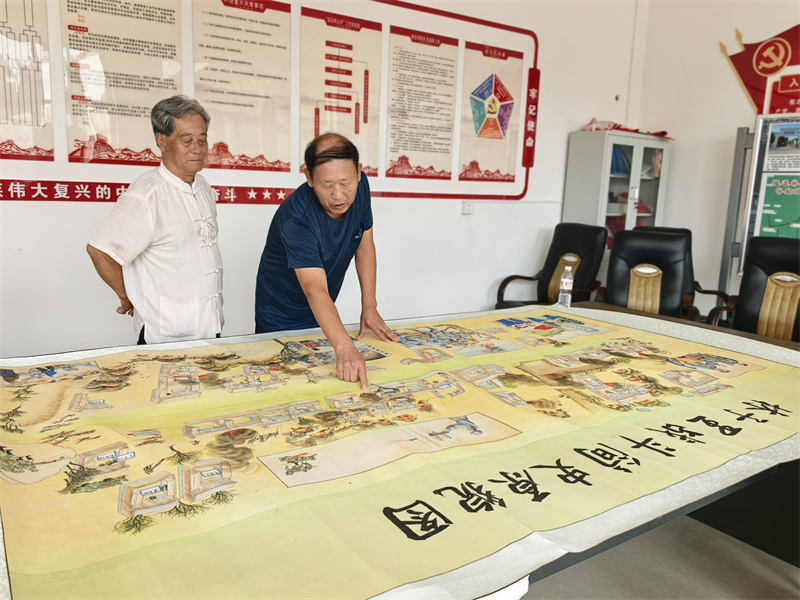 村民王俊强、李景强在《林子里战斗简史原貌图》前寻找老宅位置。