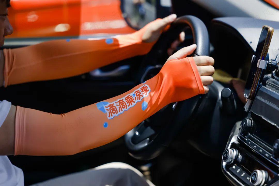 图为:上海司机戴上从滴滴清凉福利站领取的冰袖