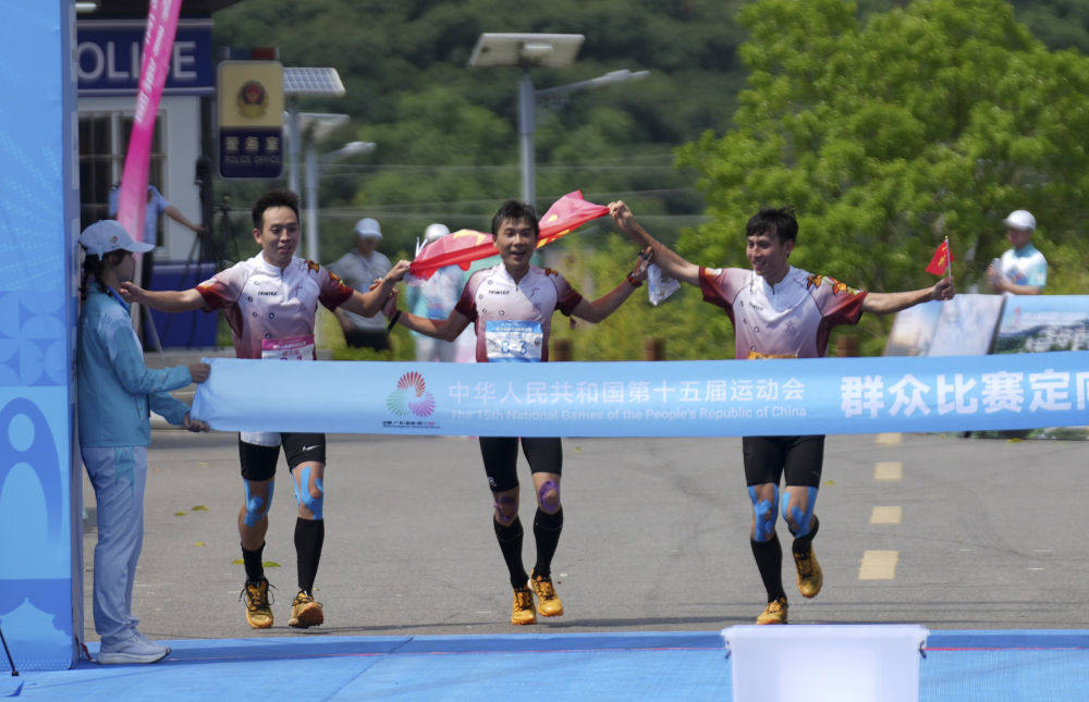 5月8日,广东队选手李卓业(中)、唐建达(左)、唐潇在男子定向接力赛中冲向终点。当日,第十五届全国运动会群众赛事活动定向接力赛决赛在广东省茂名市高州根子镇举行。新华社记者 黄国保 摄