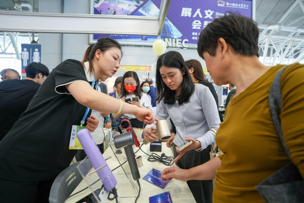 4月19日,工作人员在活动现场介绍吹风机产品。当日,2025年“外贸优品中华行江苏站”首场活动在江苏南京国际展览中心举行。新华社记者 李博 摄