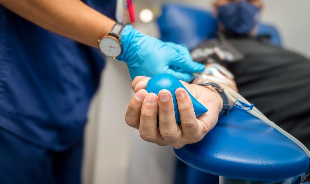 ▲一名男子在献血时手持挤压球 资料图 图据图虫创意