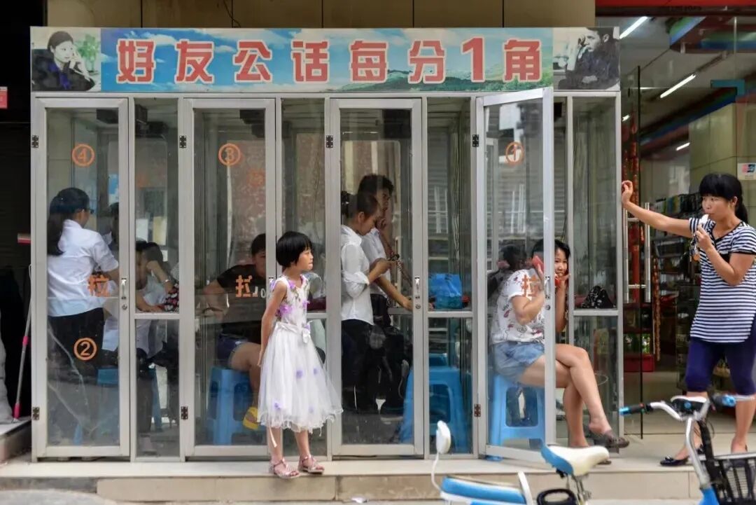 2016日,广东东莞,公共电话亭内的打工人。当时工业区的花费每分钟一角钱