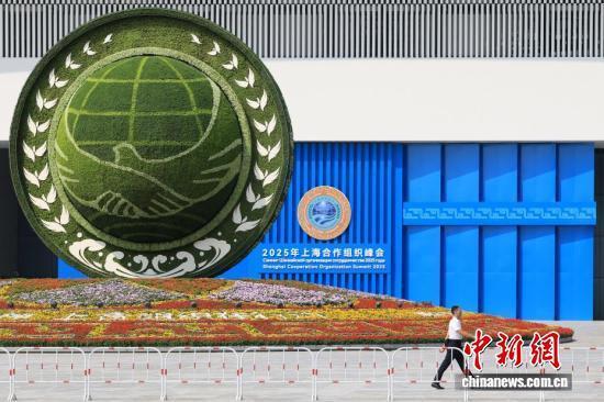 8月31日，天津，一名工作人员从2025年上海合作组织峰会主会场外的景观花坛旁经过。 中新社记者 佟郁 摄