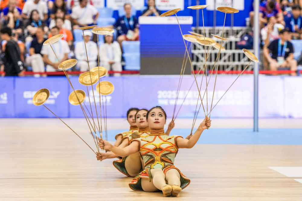 ↑8月12日,演员在成都世运会荷球混合团体赛决赛铜牌赛间隙进行杂技表演。