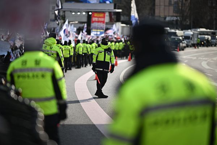 当地时间2025年1月3日,韩国首尔,警方在前总统尹锡悦的住所附近监控支持者。图片来源:视觉中国