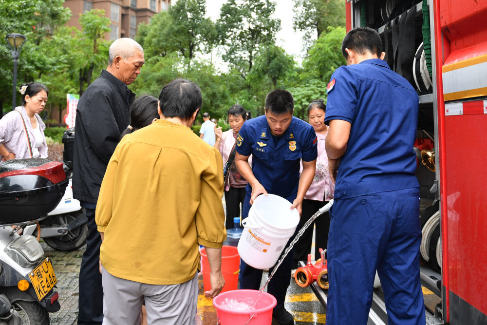 6月21日，龙山县居民在临时取水点取水。新华社记者 陈振海 摄
