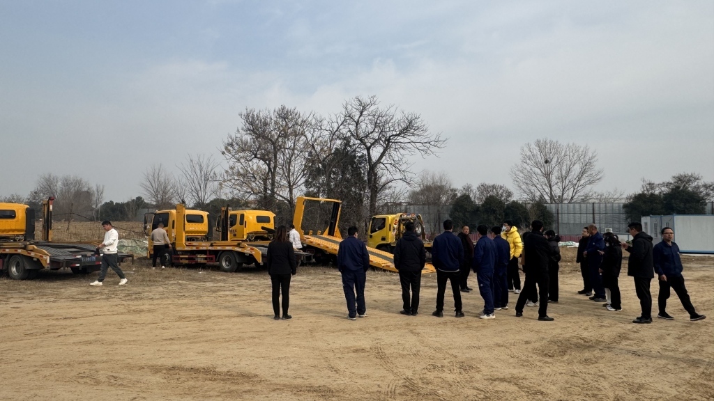 郑州东锦大众停车场内,员工们阻止银行叫来的拖车拉车。