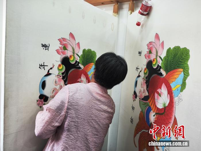“玉成号年画坊”内,画师正在绘制年画。中新网 刘越 摄