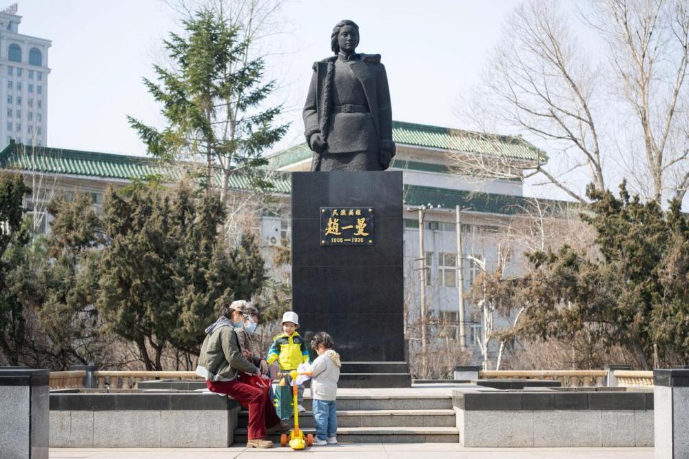 在位于哈尔滨市南岗区一曼街上的一曼公园内，市民在赵一曼塑像旁休闲。新华社记者谢剑飞摄