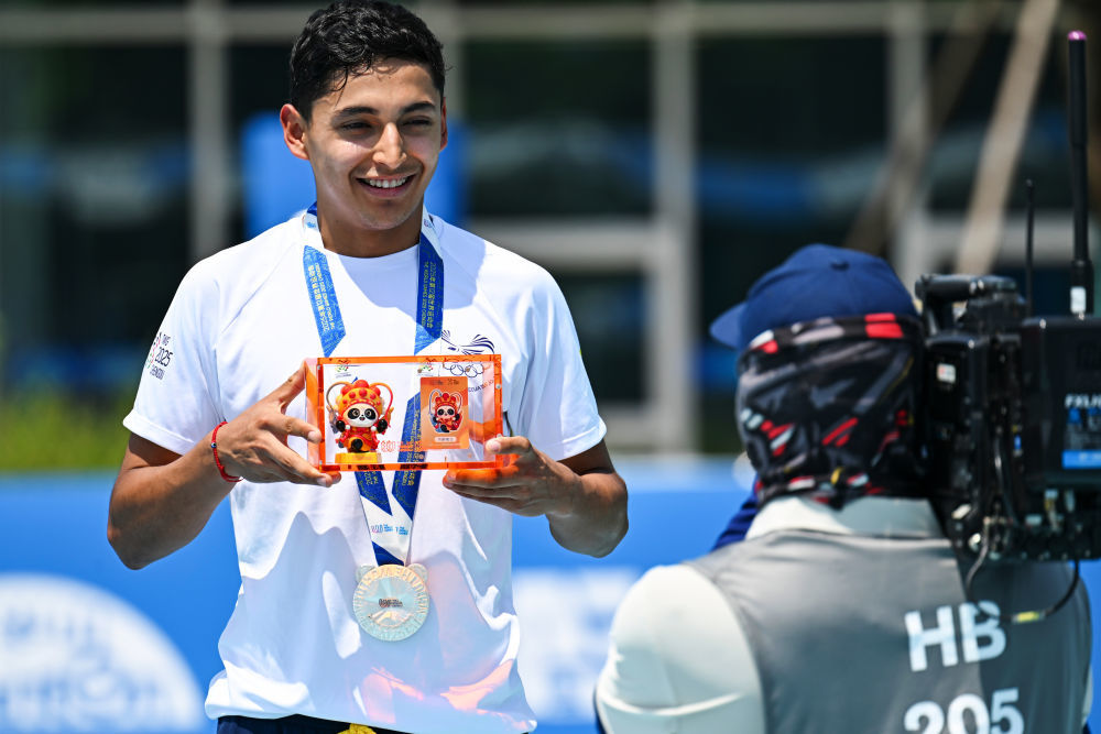 ↑8月13日,亚军厄瓜多尔队选手加西亚(左)在成都世运会速度轮滑男子公路赛(15000米淘汰)颁奖仪式上。