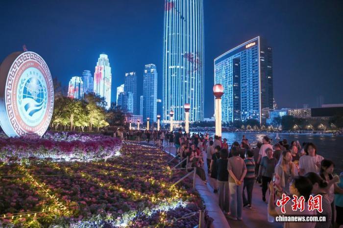 8月28日晚，市民和游客漫步天津海河畔，参观“2025上海合作组织峰会”主题花坛。 中新社记者 佟郁 摄