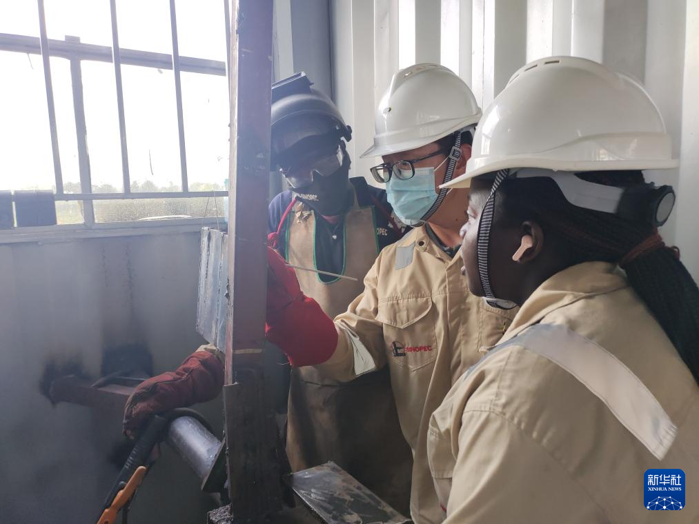 6月11日,在乌干达基贡巴石油学院,中国老师汤海东(中)为学员讲解焊接要点。新华社发(中石化供图)