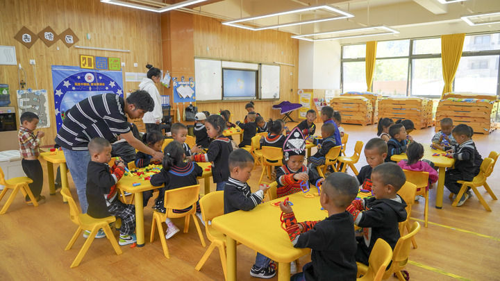 四川省昭觉县昭美社区幼儿园小朋友在老师的指导下玩游戏（2025年4月21日摄）。新华社记者 尹恒 摄