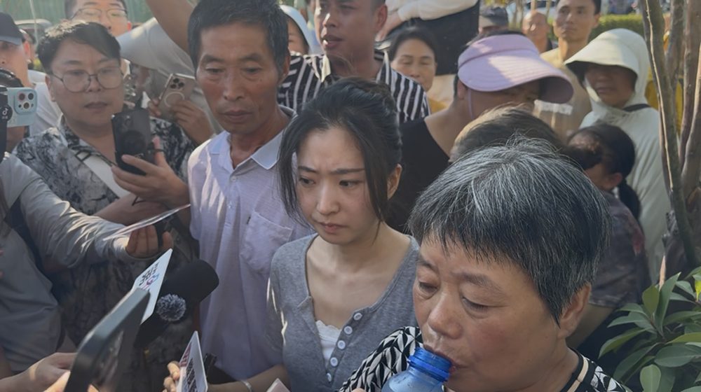 7月29日上午8点40分,案件即将开庭,“罗大美”的父母和妹妹在法院附近,接受媒体采访,有热心人给家属送来饮料。