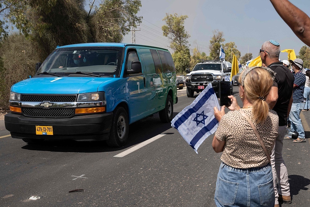 当地时间2025年10月13日,以色列南部,靠近加沙边境的雷姆军事基地外,以色列民众手持国旗聚集,迎接哈马斯从加沙地带释放的被扣押人员。视觉中国 图