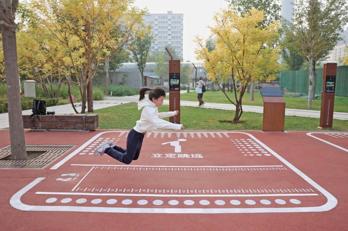 10月9日，京张铁路遗址公园，小女孩在体验AI体育训练场里的立定跳远项目。新京报记者浦峰摄