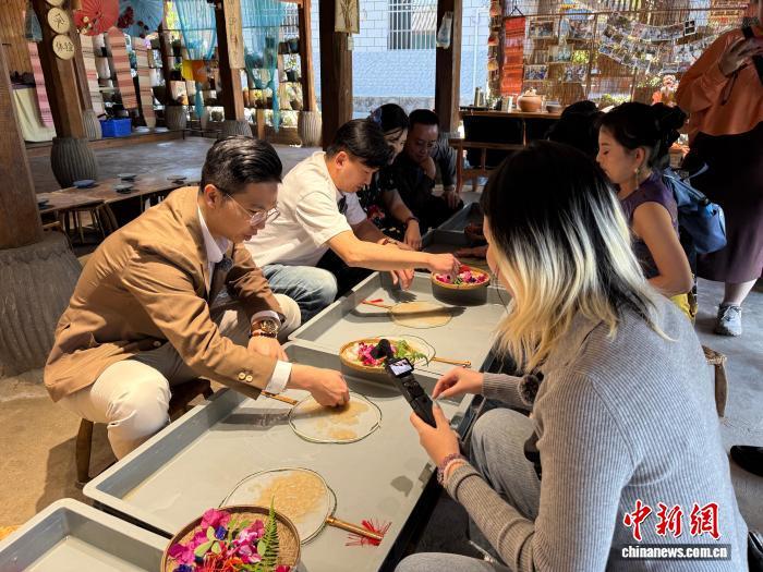 12月22日，台湾青年在云南西双版纳州体验非物质文化遗产代表性项目傣族造纸。陈静 摄