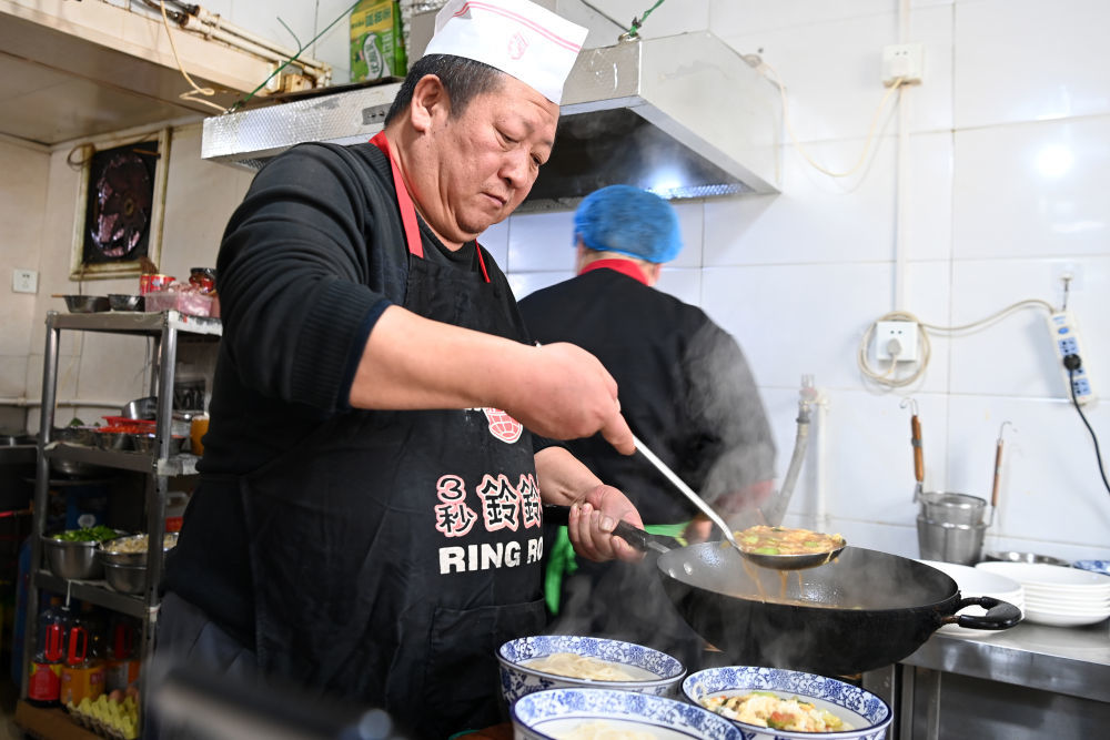 芦克清在面馆内给主顾制作臊子面。新华社记者 范培珅 摄