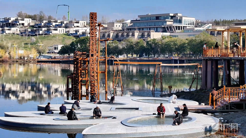 游客在温泉县户外莲花泡池体验泡温泉 (央广网发 赵星 摄)