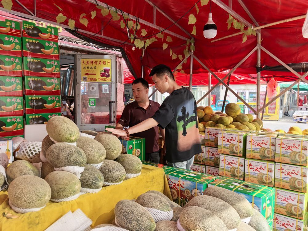 7月29日，新疆一家水果商户摊位前，顾客正在挑选甜瓜。新华社记者张瑜 摄