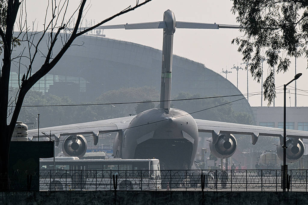 当地时间2月5日，一架美国空军C-17运输机载着被美国驱逐出境的无证印度移民抵达印度阿姆利则机场。（视觉中国）