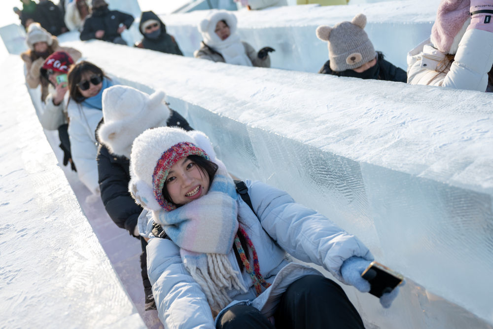 2024年12月21日，游客在哈尔滨冰雪大世界园区内玩滑梯。