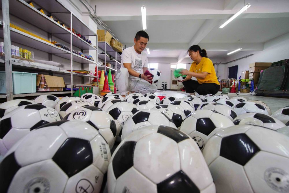 8月25日,河北省遵化市第二中学体育教师在擦拭整理足球。新华社发(刘满仓摄)