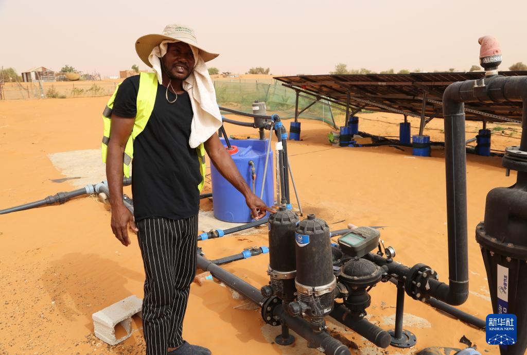 5月22日,在毛里塔尼亚西部特拉扎区比尔·巴尔卡村,中非绿色技术公园园区灌溉技术工人穆罕默德·伊塞勒穆介绍园区智能灌溉设备。新华社记者 司源 摄