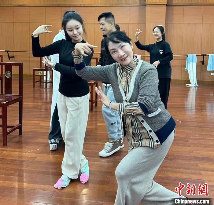 图为苗洁(前)指点学生动作。(资料图，受访者供图)