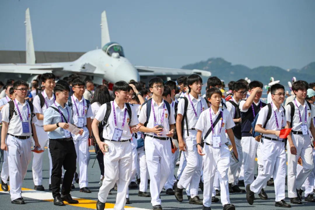 ▲青年学生在山东舰甲板参观舰艇开放区 杨捷 摄