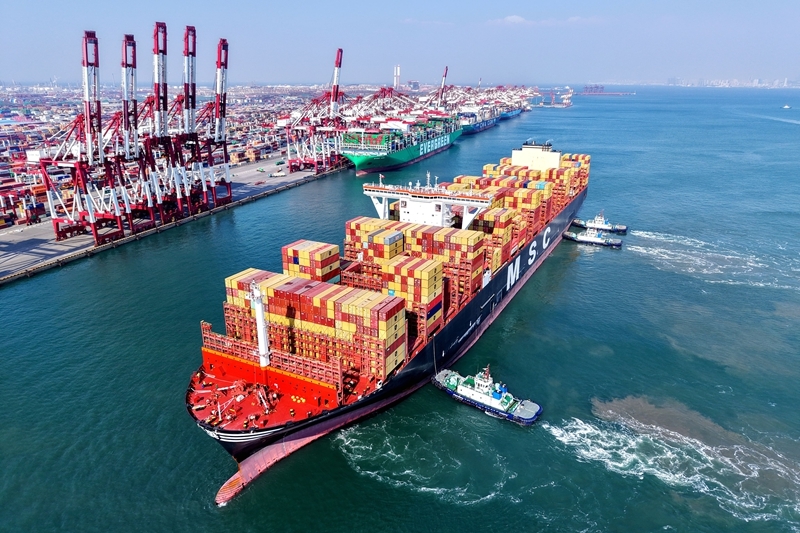 2月23日，山东港口青岛港，一艘货轮在拖船辅助下停靠码头。图片来源：新华社