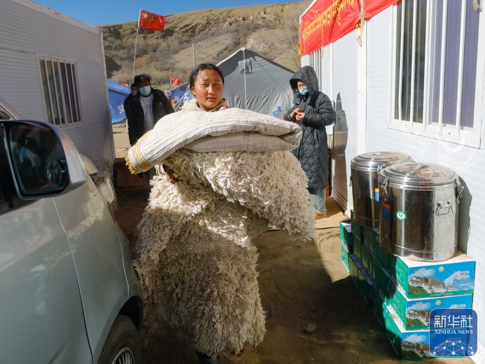 1月10日，在定日县长所乡古荣村，受灾群众准备将个人物品从临时安置帐篷搬入板房。