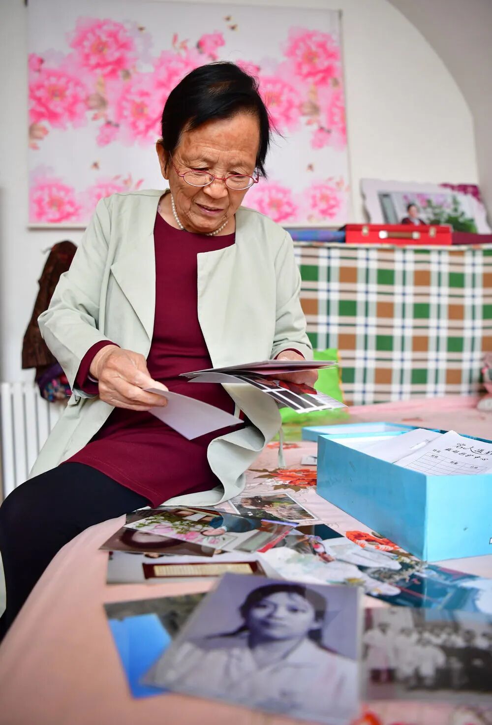 2018年4月29日,路生梅在家中翻看她年轻时候的照片。新华社记者 邵瑞 摄