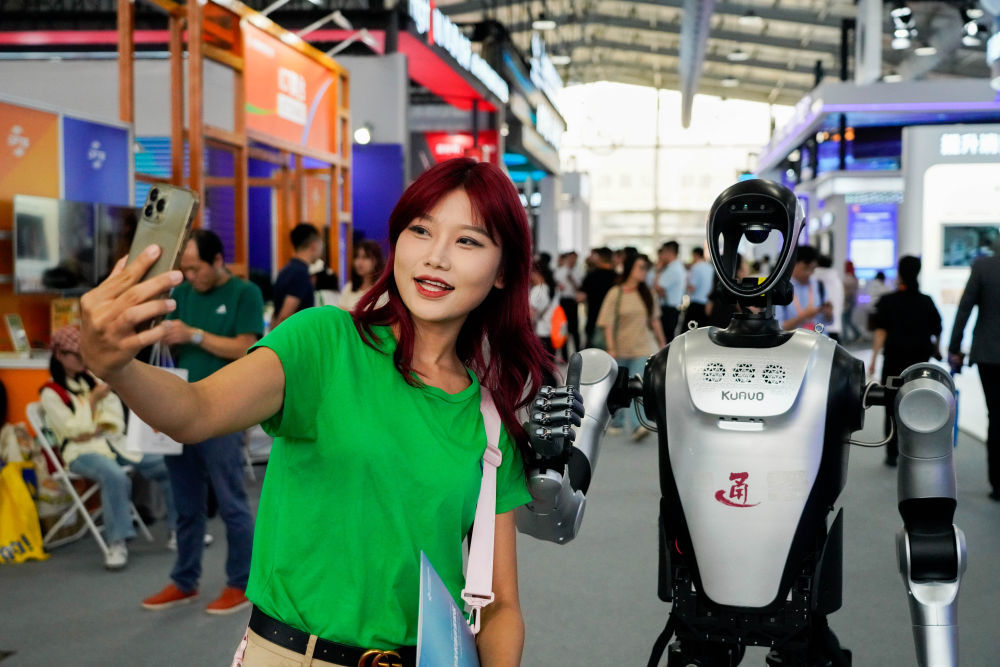 ↑ 9月11日，参观者与机器人合影。