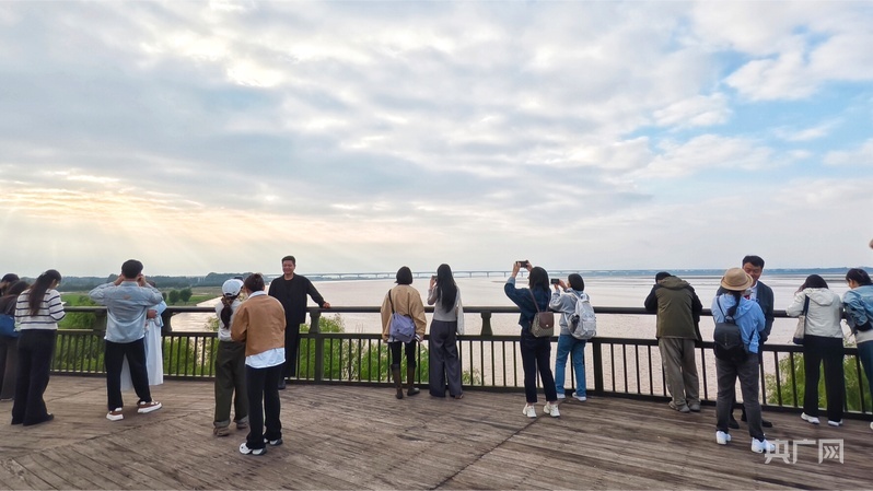 游客在黑岗口河势观测台拍照打卡（央广网记者 郝振青 摄）