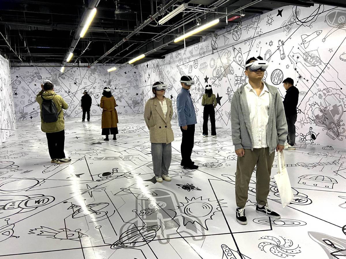 3月27日，在北京市石景山区首钢园的沉浸式科幻空间展厅，参观者戴上头显装置，体验遥在（山东）数字科技有限公司打造的星际奇航旅程体验项目。（图片来源：新华社）