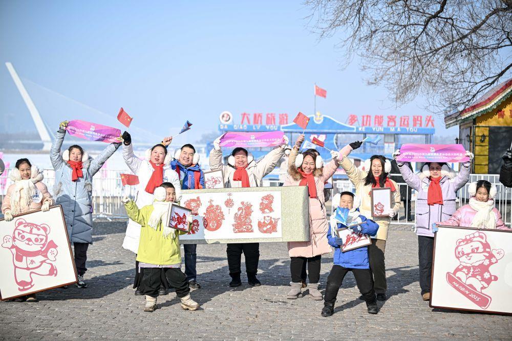 △2月3日，观众在亚冬会火炬传递沿途为火炬手加油。