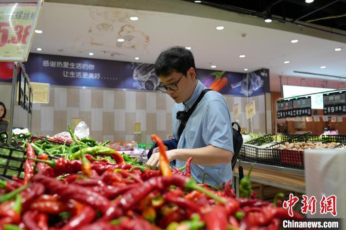 俞佳伟已在江西上饶工作、定居，图为他下班后在超市买菜。吴思瑜 摄