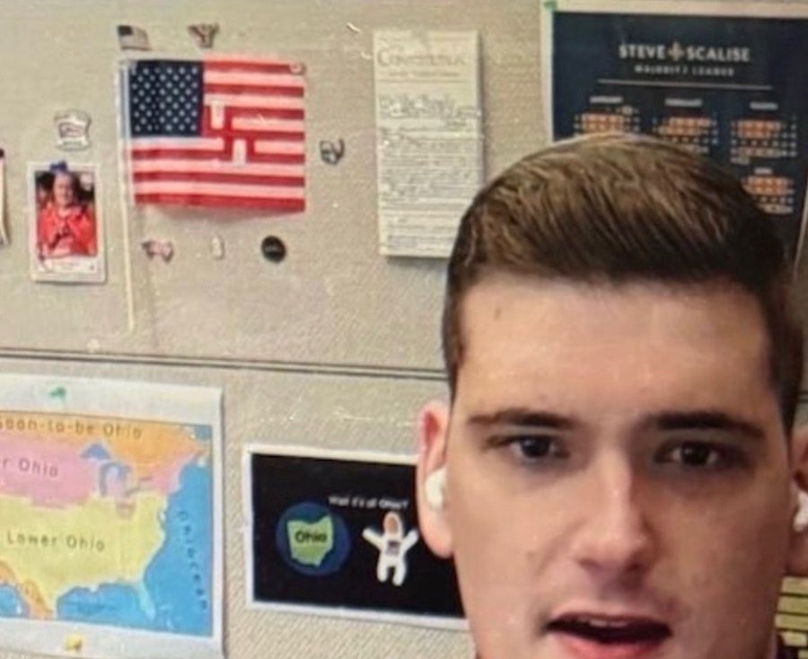 网上传播的图片显示,泰勒的助理安杰洛·埃利亚身后出现一面美国国旗——但其部分红白条纹图案,被扭曲成纳粹标识。