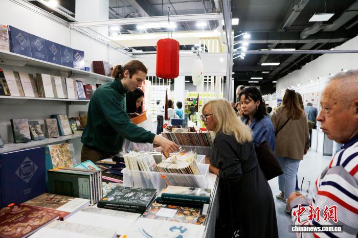 当地时间9月4日，莫斯科全俄展览中心，读者在第38届莫斯科国际书展尚斯国际出版集团展台挑选中国传统文化俄译本图书。中新社记者　田冰　摄