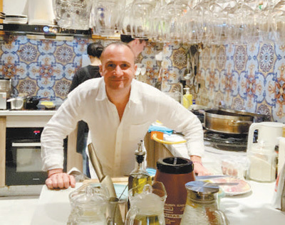 马努在餐厅后厨备餐。受访者供图