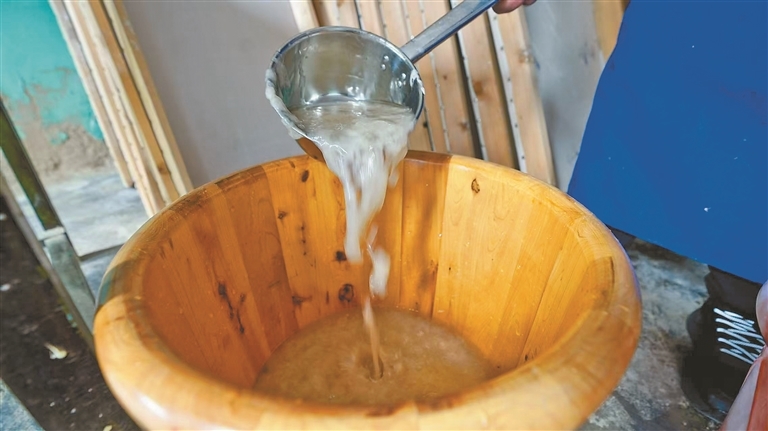 图为阿旺曲央反复搅拌纸浆，持续调和使其更紧密均匀。