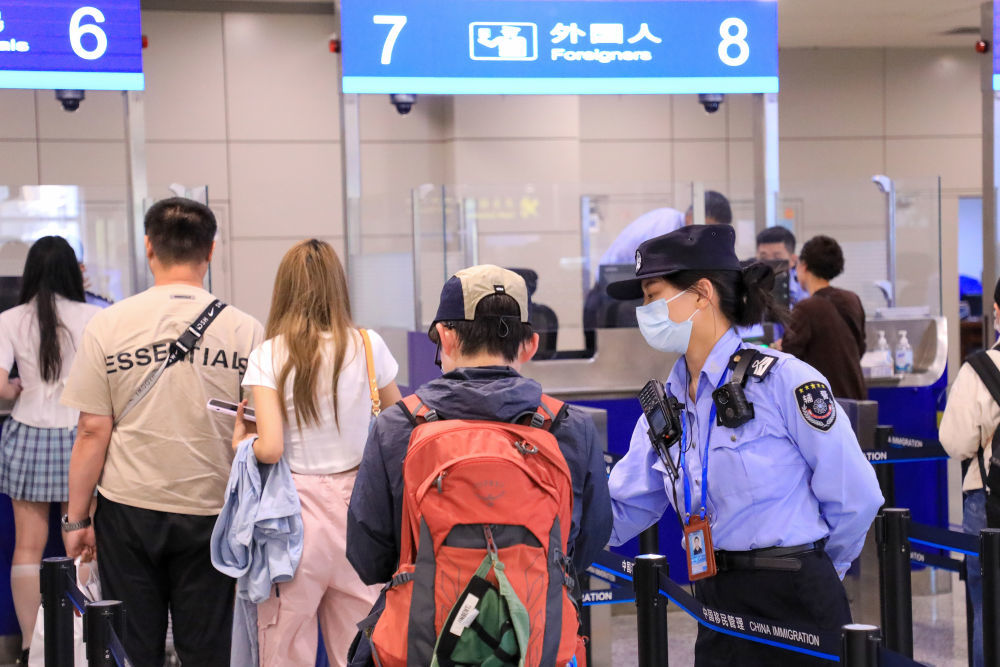 5月3日，无锡边检站工作人员在无锡硕放机场边检入境现场引导外籍游客。新华社发（朱吉鹏摄）