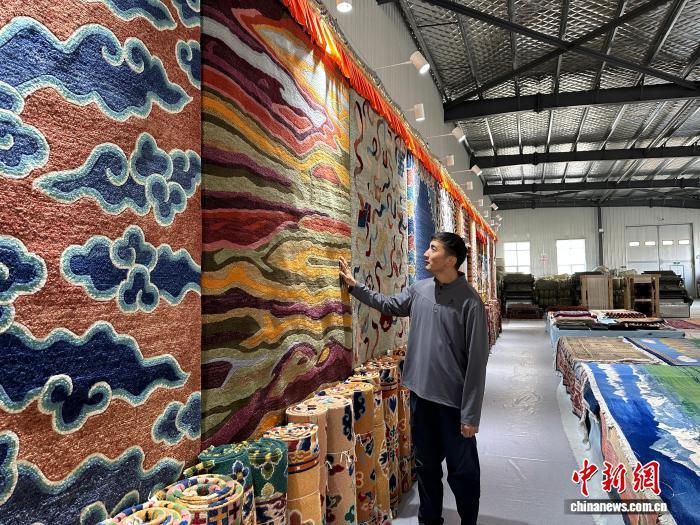 11月5日,贡保扎西介绍该公司生产的不同款式的现代藏毯。中新社记者 丁思 摄