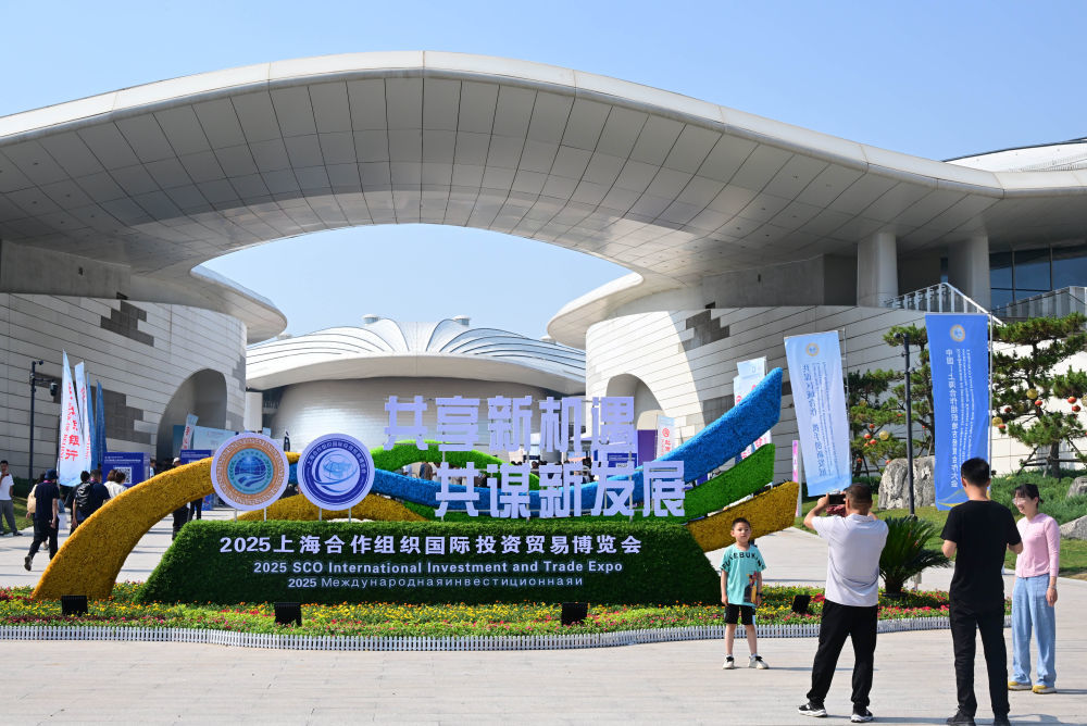 2025年7月18日，人们在青岛·上合之珠国际博览中心外拍照留念。新华社记者 李紫恒 摄