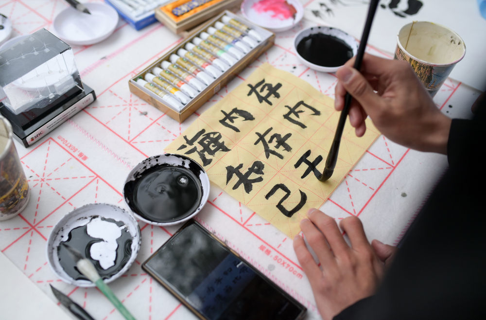 2025年4月19日，在哈萨克斯坦阿拉木图，一名中国文化爱好者在“国际中文日”庆祝活动上体验书法。
