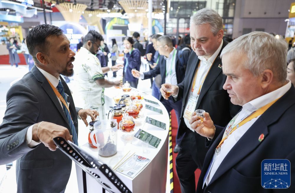 ↑ 11月7日，在第八届进博会国家展斯里兰卡馆，展商（左一）推介锡兰红茶。新华社记者 孟晨光 摄